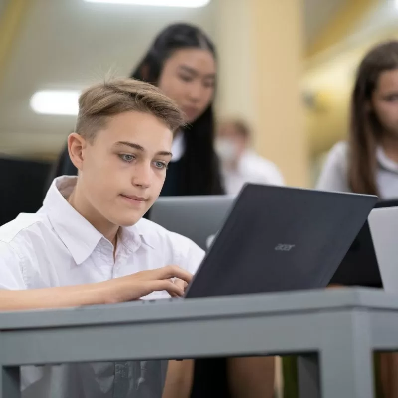 School essentials - a student using a laptop in class.