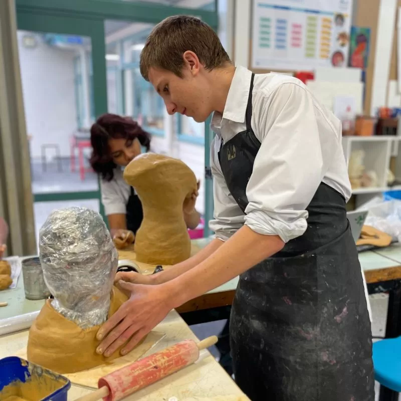 Co-curricular activities - a student sculpting with clay