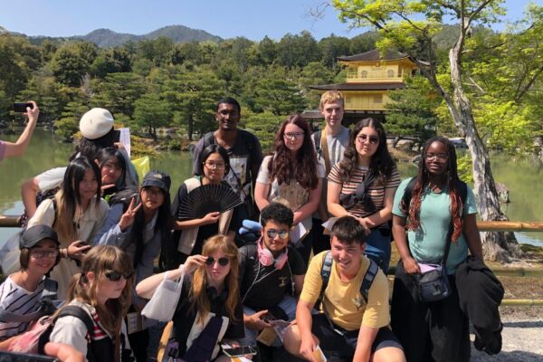 5 Students smiling for photo at a Japanese shrine