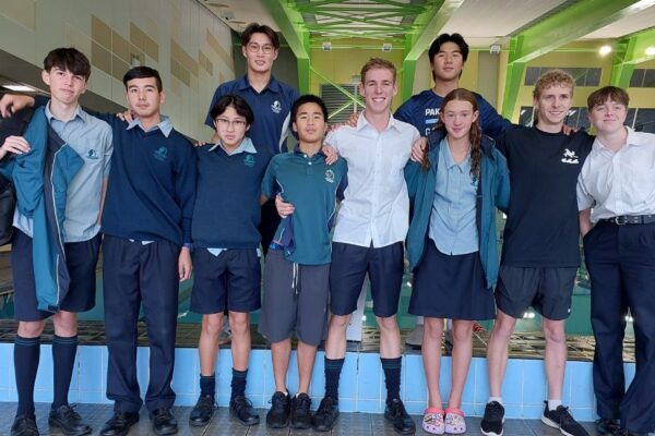 5 Pakūranga College swimmers posing for a photo at a competition