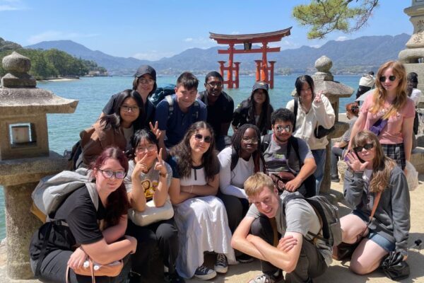 8 Students posing in front of a Torii Gate in Japan