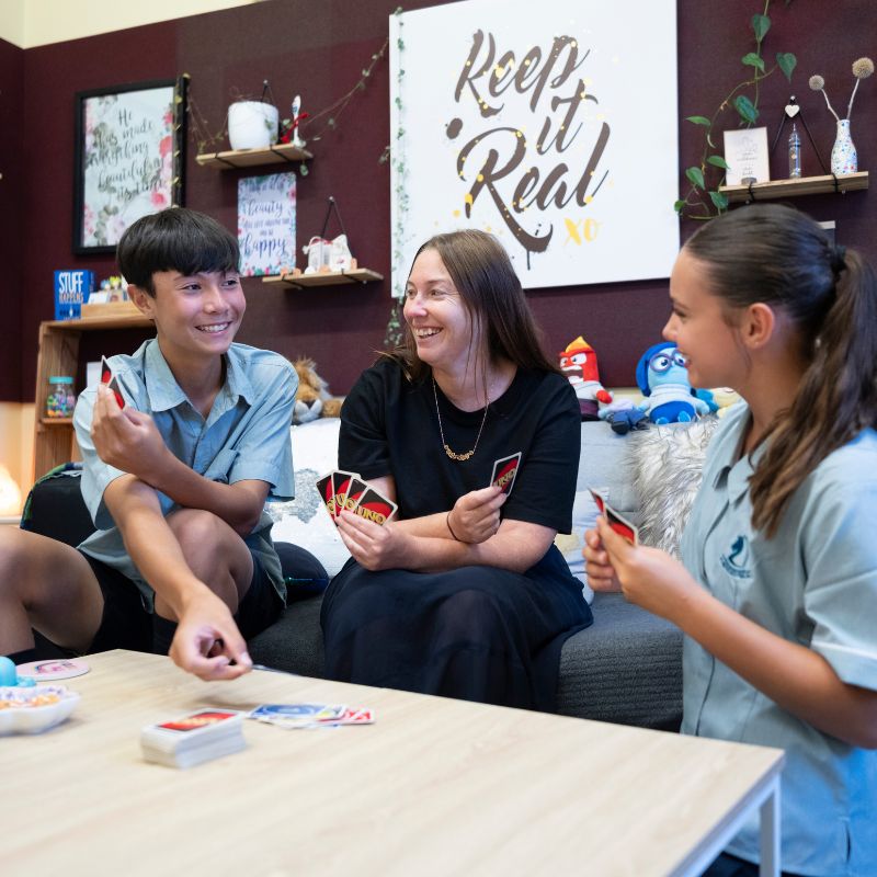 Student support - students and youth worker play Uno