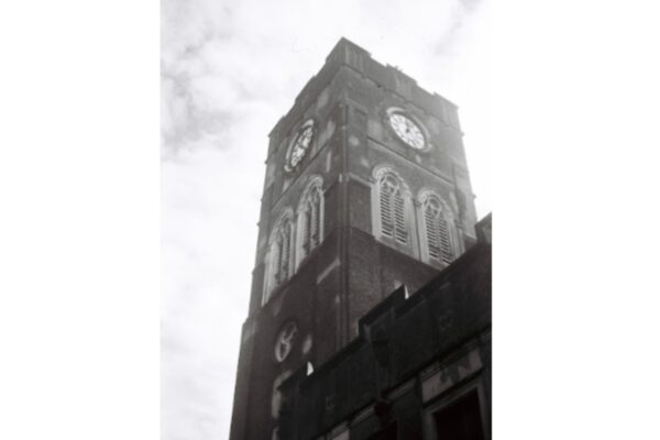 The back of the tower, showing the clock dials. The church bells are located just under it and were cast in the 1940s and 50s.
This photo required some walking around to get the right angle, as the sun would have caused lens flare. Kodak advised against taking photos pointed upward, but I see no problem with it. Note the 15-minute time difference on the clock since the first photo.